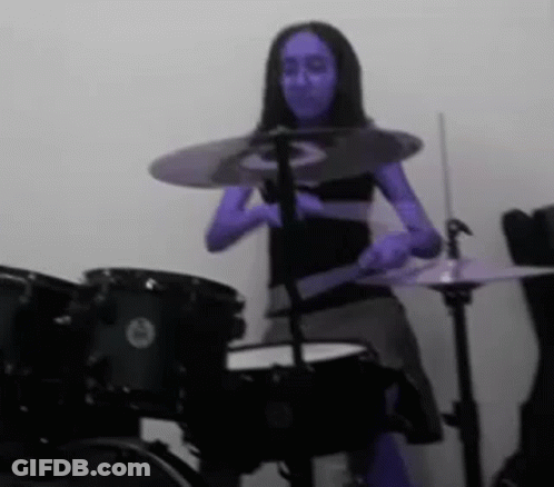 Woman With Blue Paint Playing Drums GIF