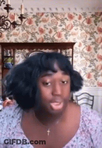 Woman With Cross Necklace And Wig Making Funny Face GIF