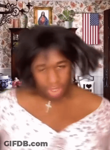 Woman With Cross Necklace In Front Of American Flag And Jesus Picture GIF