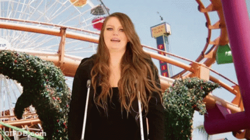 Woman With Crutches In Front Of Pacific Park Roller Coaster GIF