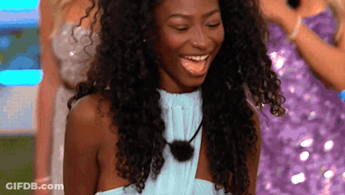 Woman With Curly Hair And Blue Top Smiling GIF