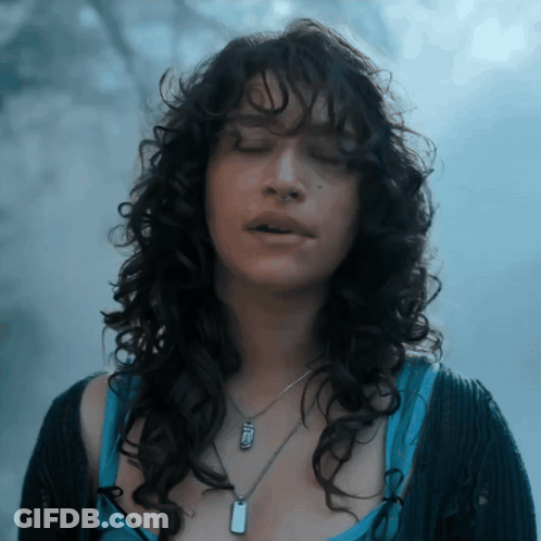Woman With Curly Hair And Dog Tag Necklace GIF