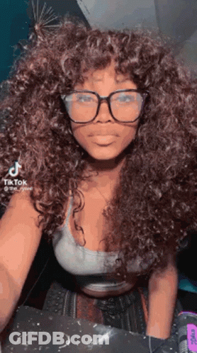 Woman With Curly Hair And Glasses In Crop Top And White Tank Top GIF