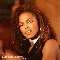 Woman With Curly Hair And Hoop Earrings In Black Top GIF