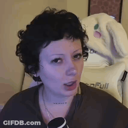 Woman With Curly Hair And Neck Tattoo Sitting In Front Of Heaven Pillow GIF