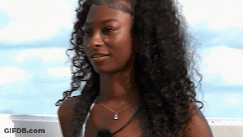Woman With Curly Hair And Necklace Smiling GIF