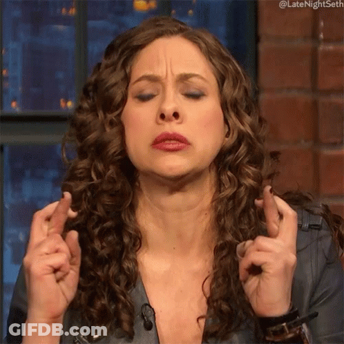 Woman With Curly Hair Crosses Fingers GIF