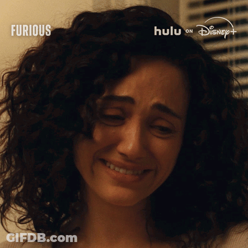 Woman With Curly Hair Crying In Front Of Furious Sign GIF