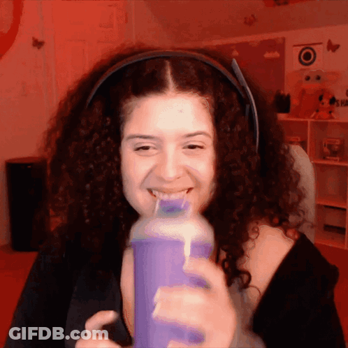 Woman With Curly Hair Drinking Purple Bottle GIF