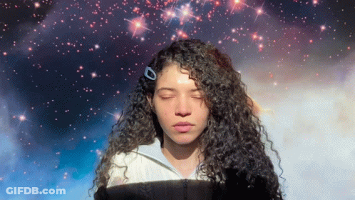 Woman With Curly Hair Eyes Closed In Front Of Galaxy GIF
