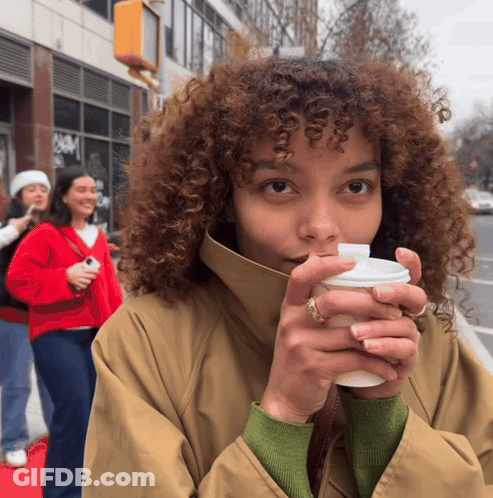Woman With Curly Hair Holding Coffee GIF