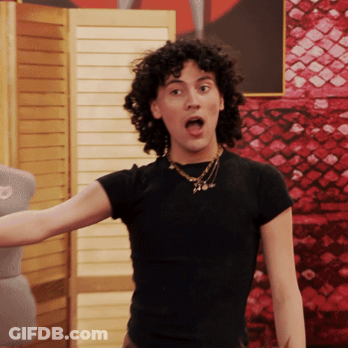 Woman With Curly Hair In Black Shirt And Necklace GIF