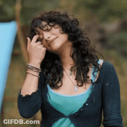 Woman With Curly Hair In Blue Sweater And Tank Top GIF