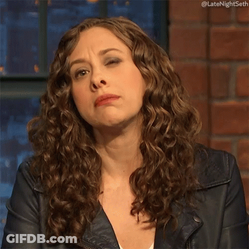Woman With Curly Hair In Leather Jacket Making Face GIF