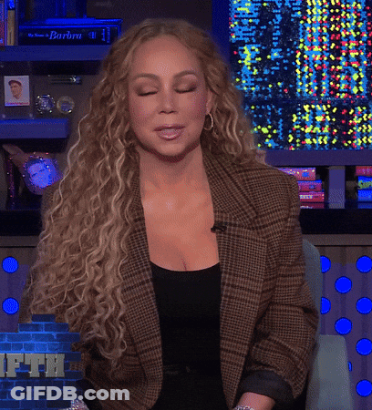 Woman With Curly Hair In Plaid Jacket And Black Top GIF