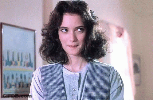 Woman With Curly Hair In Plaid Vest GIF