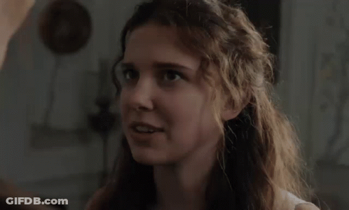 Woman With Curly Hair Looking At Man In Room GIF