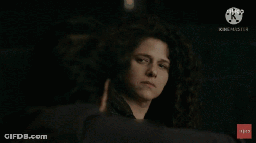 Woman With Curly Hair Looking At Man With Hebrew Text GIF