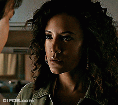Woman With Curly Hair Looks At Man GIF