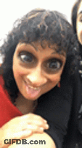 Woman With Curly Hair Making Funny Face Next To Another Woman GIF