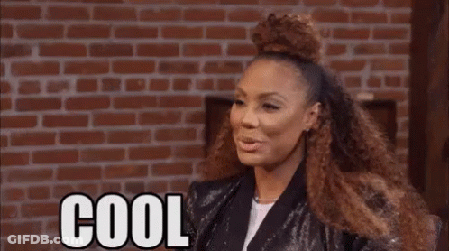 Woman With Curly Hair Saying Cool Beans By Brick Wall GIF
