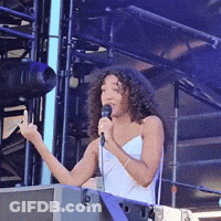 Woman With Curly Hair Singing Into Microphone GIF