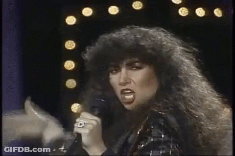 Woman With Curly Hair Singing Into Microphone GIF