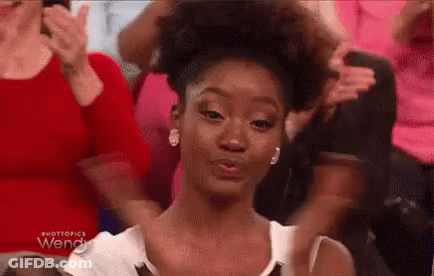 Woman With Curly Hair Sitting In Crowd GIF