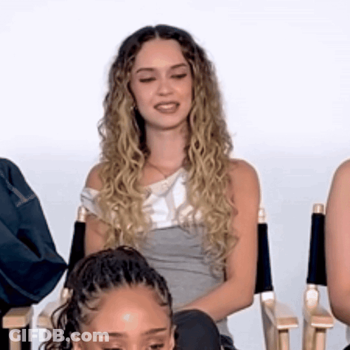 Woman With Curly Hair Sitting In Director's Chair GIF