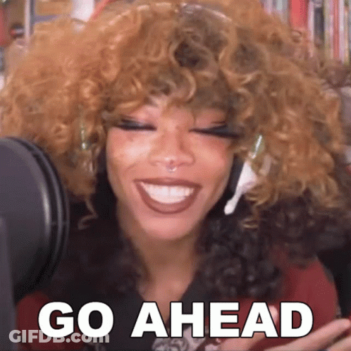 Woman With Curly Hair Smiling At Microphone Saying Go Ahead GIF