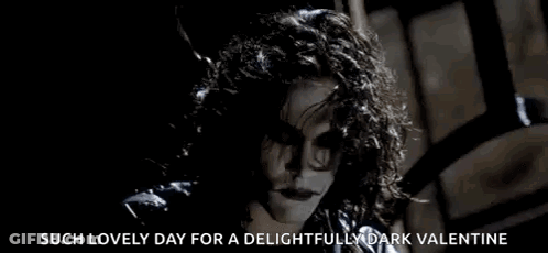 Woman With Curly Hair Smiling In Dark Room GIF