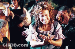 Woman With Curly Hair Smiling In Front Of Group GIF
