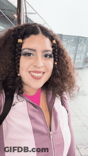 Woman With Curly Hair Smiling In Pink Shirt GIF