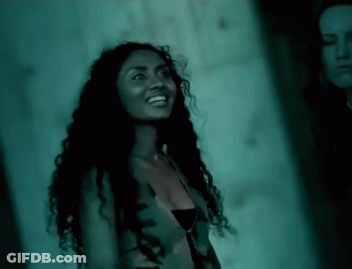 Woman With Curly Hair Smiling Next To Another Woman GIF