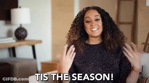 Woman With Curly Hair Smiling On Couch GIF