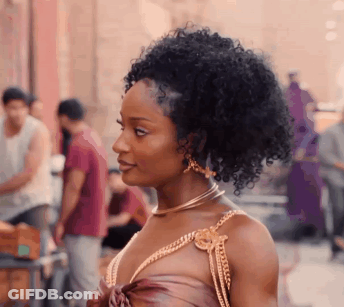 Woman With Curly Hair Wearing Necklace And Earrings On Street GIF