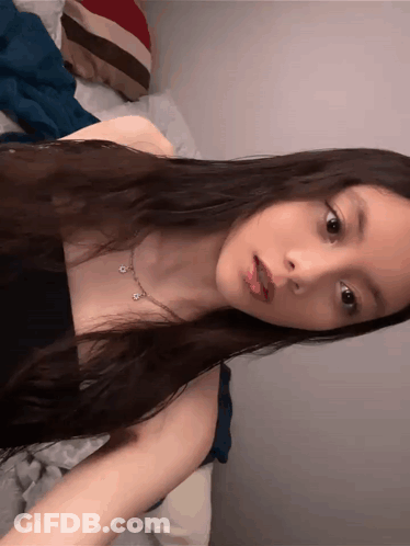 Woman With Dark Hair In Black Tank Top And Necklace GIF