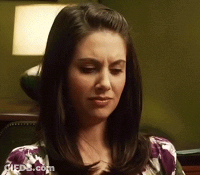 Woman With Dark Hair In Purple Floral Shirt GIF