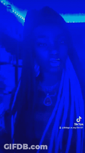 Woman With Dreadlocks In Dark Room With Blue Lights GIF