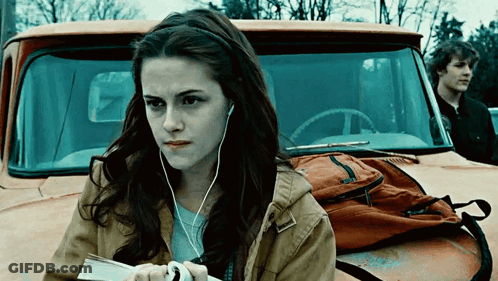 Woman With Ear Buds Standing In Front Of Truck GIF