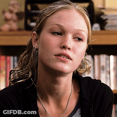 Woman With Earrings And Necklace Looking At Camera GIF