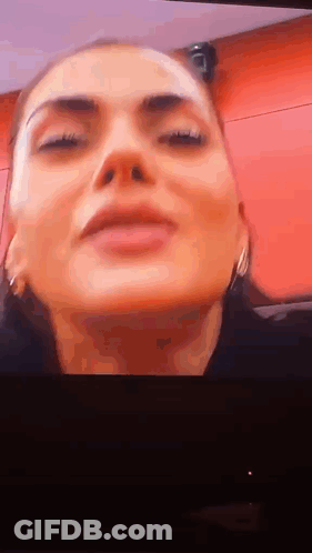 Woman With Eyes Closed On Red Background GIF