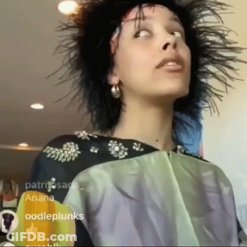 Woman With Feathers In Hair Looking Up GIF