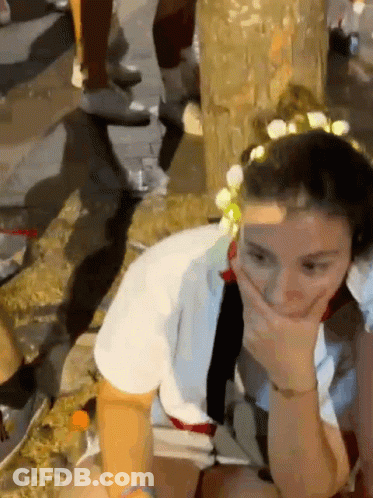 Woman With Flower Crown Covering Mouth GIF