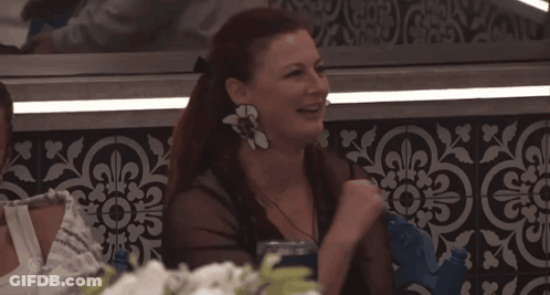 Woman With Flower Earring At Table GIF