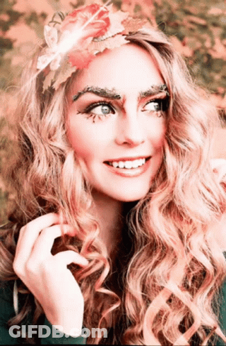 Woman With Flower In Hair And Leaves On Eyebrows GIF