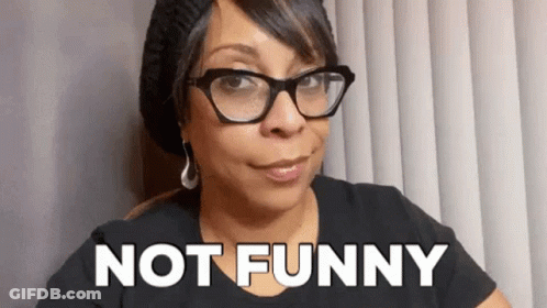 Woman With Glasses And Beanie Saying Not Funny GIF