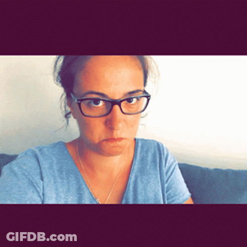Woman With Glasses And Blue Shirt Looks Angry GIF