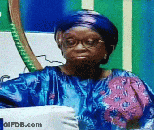 Woman With Glasses And Blue Shirt Sitting By Flag GIF