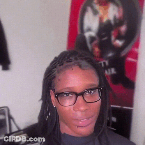 Woman With Glasses And Dreadlocks In Front Of T.I. Air Poster GIF
